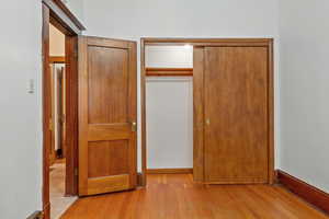 Unfurnished bedroom with light wood-type flooring and a closet
