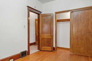 Unfurnished bedroom featuring light wood-style floors and a closet