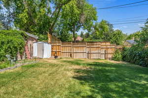 Fenced backyard with a storage unit