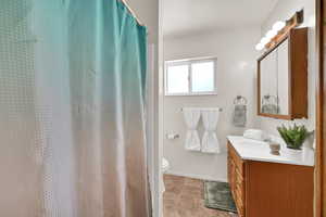Full bath featuring vanity and toilet