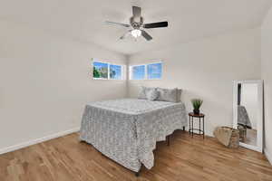 Bedroom with light wood-style flooring, ceiling fan, and a textured ceiling