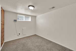 Spare room with carpet flooring and a textured ceiling