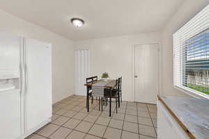 Dining room featuring a textured ceiling and light tile patterned flooring