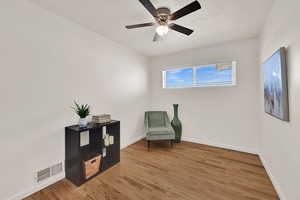 Living area with light wood-style flooring and a ceiling fan