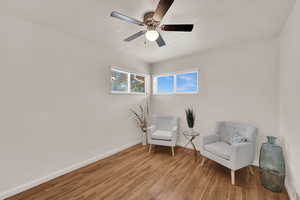 Sitting room featuring wood finished floors, a textured ceiling, and a ceiling fan