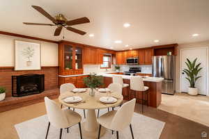 Dining area with a brick fireplace, recessed lighting, light colored carpet, a ceiling fan, and ornamental molding