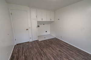 Laundry area featuring cabinet space, dark wood-type flooring, hookup for a washing machine, and hookup for an electric dryer