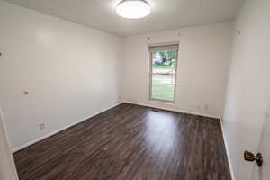 Spare room with dark wood finished floors and a textured ceiling