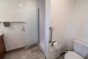 Full bathroom featuring vanity, a shower stall, and light tile patterned flooring