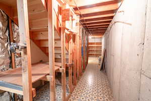 Unfinished below grade area featuring light flooring and stairs