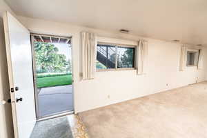 Doorway featuring carpet flooring and baseboards