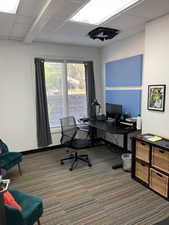 Office space featuring a drop ceiling and dark carpet