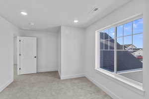 Empty room featuring light carpet and recessed lighting
