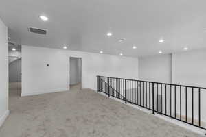 Unfurnished room with light carpet and recessed lighting