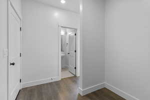 Corridor featuring dark wood finished floors and baseboards