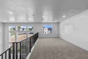 Carpeted spare room with recessed lighting and a textured ceiling