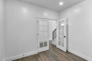 Spare room with dark wood-style floors and recessed lighting