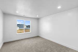 Empty room with light colored carpet, recessed lighting, and a textured ceiling