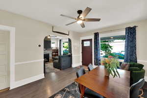 Dining room with ceiling fan, wood finished floors, and arched walkways