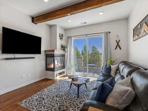 Living area featuring wood finished floors, recessed lighting, beam ceiling, and a multi sided fireplace