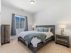 Bedroom with light colored carpet and baseboards