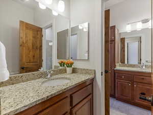 Bathroom featuring vanity, two sinks, and light tile patterned floors