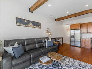 Living room featuring beam ceiling, dark wood-style flooring, and recessed lighting