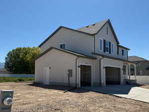 View of side of home featuring board and batten siding, an attached garage, and concrete driveway