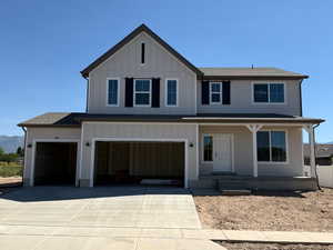 View of front of property featuring covered porch, board and batten siding, concrete driveway, and a garage