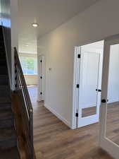 Hall with stairs, dark wood-style floors, and a textured ceiling