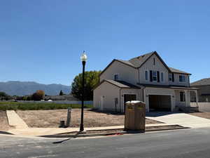 Modern inspired farmhouse featuring concrete driveway, a garage, and a mountain view