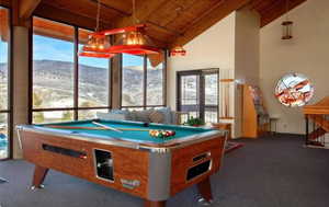 Playroom with a wooden ceiling with exposed beams, dark colored carpet, billiards, french doors, and high vaulted ceiling