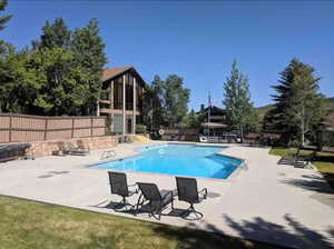 Community pool with a patio area and a balcony