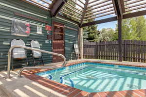 View of swimming pool featuring a hot tub and a pool