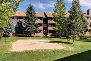 View of home's community featuring a lawn and volleyball court
