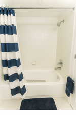Bathroom with shower / bath combination with curtain