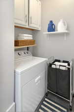 Washroom featuring washer / dryer and cabinet space