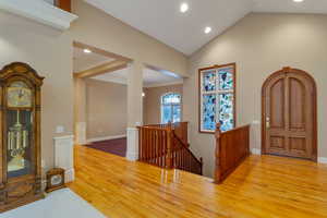 Entryway with light wood-style floors, recessed lighting, crown molding, and high vaulted ceiling