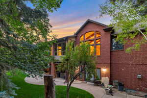 View of front of house with a patio and brick siding