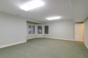 Empty room featuring carpet flooring and baseboards