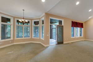 Unfurnished dining area with carpet, a chandelier, and recessed lighting