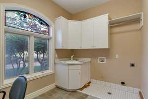 Laundry room with hookup for a washing machine, hookup for an electric dryer, and cabinet space