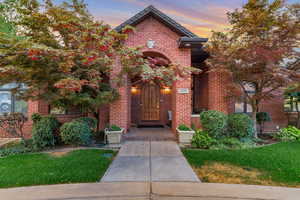 View of front facade featuring brick siding and a lawn