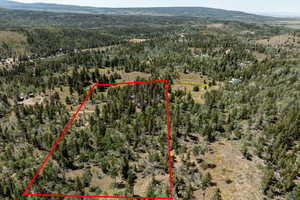 Aerial view of property's location with property parcel outlined and a mountainous background