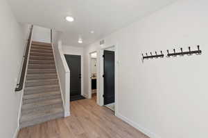 Hall featuring stairway and light wood-type flooring