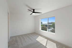 Unfurnished room with light colored carpet and ceiling fan