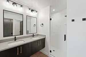 Full bathroom with a shower stall, dark wood-style floors, recessed lighting, and a textured ceiling