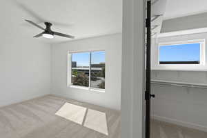 Unfurnished bedroom featuring light carpet and ceiling fan
