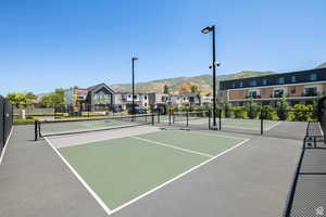 View of tennis court with a residential view, a mountain view, and community basketball court