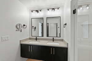 Full bath featuring a sink and a shower stall